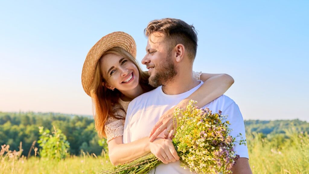 Novia abrazando a su novio con un ramo de flores